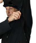 Man wearing a black coat with a hood, adjusting it on a white background