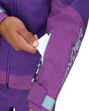 Purple snowsuit with geometric pattern and brand logo, close-up of sleeve and hand.