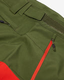 Close-up of green and red jacket with zippers and pockets on a white background