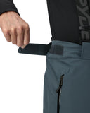 Person adjusting a black strap on a black jacket with a visible brand logo.