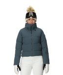 Person wearing a blue puffer jacket, white pants, and winter accessories on a white background