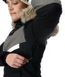 Person wearing a black and gray winter coat with fur-lined hood on a white background