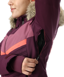 Close-up of a person wearing a purple winter jacket with fur hood on a white background