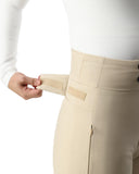 Person wearing beige pants with a white shirt, adjusting a beige patch on the waistband.