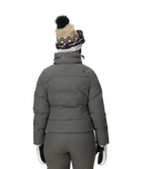 Person wearing a gray winter coat, pants, and hat on a white background