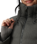 Person wearing a gray jacket with a close-up of the zipper.