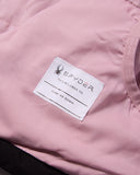 Close-up of a pink jacket with a Spyder label on a matching pink background