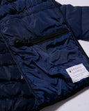 Close-up of a navy blue puffer jacket with a brand label on a white background