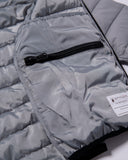 Close-up of a gray puffer jacket with a black zipper and Spyder label.