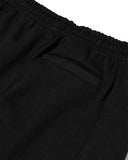 Close-up of black pants with a white background