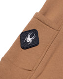 Brown pants with a spider logo patch on a white background